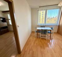 Jídelní stůl se židlemi v 1-pokojovém bytě s podlahou s dřevěným dekorem.