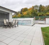 Terasa rodinného domu v Domaniži se zahradním nábytkem a zakrytým bazénem.