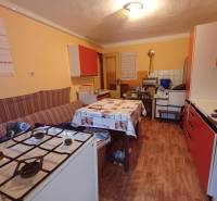 Kuchyně v rodinném domě s plynovým sporákem a podlahou s dřevěným dekorem.