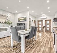 Jídelní kout ve 3-pokojovém bytě s podlahou s dřevěným dekorem a stylovým zrcadlem.