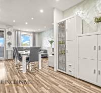 Světlý interiér 3-pokojového bytu s podlahou s dřevěným dekorem a bílým nábytkem.