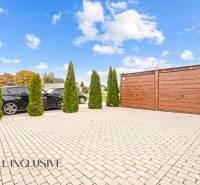 Parkoviště u 3pokojového bytu v Gabčíkovu, s auty a dřevěnou garáží.