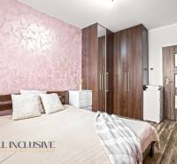 Ložnice s postelí, skříní a podlahou s dřevěným dekorem ve 3pokojovém bytě.