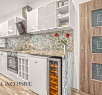 Kuchyně ve 3-pokojovém bytě s podlahou s dřevěným dekorem a mramorovou pracovní deskou.