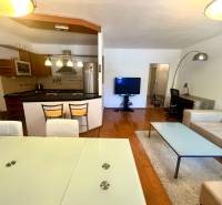 Obývací pokoj v 3pokojovém bytě s kuchyní, jídelním stolem a pohodlným sezením.