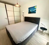 Ložnice v 3-pokojovém bytě s šatní skříní a nočním stolkem.