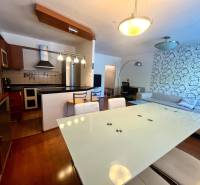 Kuchyně a obývací pokoj v 3pokojovém bytě s moderním nábytkem a dekorativní stěnou.