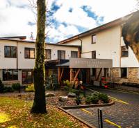 Budova hotelu se stromy a padajícím listím ve Štrbě na ulici Lúčna.