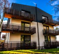 Bytový dům na ulici Lúčna v Štrbě s moderními balkony a okolní zelení.