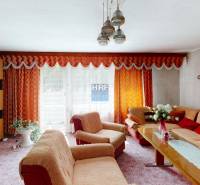 Obývací pokoj v rodinném domě s oranžovými závěsy a stylovým zařízením.