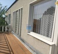 Balkon rodinného domu na ulici Vieska ve městě Radošovce s dřevěným zábradlím.