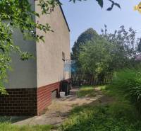 Zahrada u rodinného domu na Viesce v Radošovicích s chodníkem a plotem.