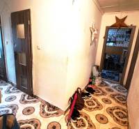 Chodba v 2-pokojovém bytě s dekorativní dlažbou a nábytkem.