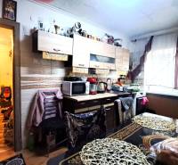 Kuchyně v 2-pokojovém bytě se světlou podlahou s dřevěným dekorem a bohatým zařízením.