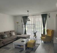 Obývací pokoj v rodinném domě s pohodlnou sedačkou a žlutým křeslem.