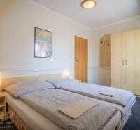 Dvoulůžkový pokoj s postelí, nočními stolky a skříní v hotelech a penzionech.