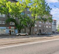 Ulice Vajnorská v Bratislavě - Novém Městě, kde jsou obytné domy a obchody.