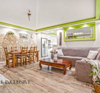 Obývací pokoj v rodinném domě s kamennou stěnou a podlahou s dřevěným dekorem.