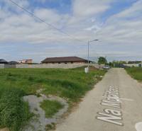 Pozemky - bydlení v Čani s výhledem na klidné předměstí a prázdnou cestu.