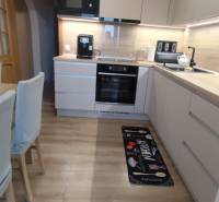 Kuchyně s podlahou s dřevěným dekorem v 3-pokojovém bytě, s moderním vybavením a dekorem.