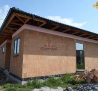 Rodinný dům v Novém Městě nad Váhom, zobrazuje rozestavěnou stavbu s cihlovou fasádou.