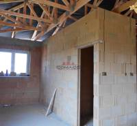 Hrubá stavba rodinného domu na ulici v Novém Městě nad Váhom s pohledem na interiér.