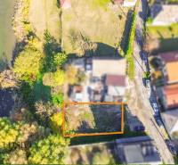 Letecký pohled na pozemky v Jahodné, obklopené zelení a vodní plochou.