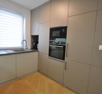 Kuchyně v rodinném domě s podlahou s dřevěným dekorem a vestavěnými spotřebiči.