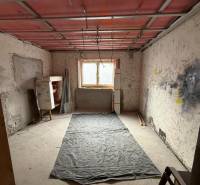 Místnost v rekonstrukci v rodinném domě s podlahou s dřevěným dekorem.