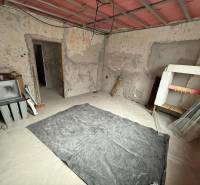 Interiér rodinného domu ve Staré Kremničce s odkrytými stěnami a podlahou.