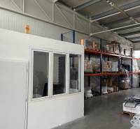 Sklady a haly s regály, zbožím a vysokozdvižným vozíkem.