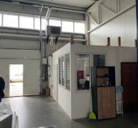 Interiér skladů a hal s přechodovou bránou a malou kanceláří nahoře.