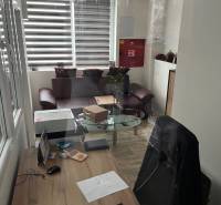 Kancelář ve skladech a halách s psacím stolem a podlahou s dřevěným dekorem.