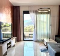 Obývací pokoj v jednopokojovém bytě s mramorovou podlahou a výhledem na hory.