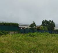 Pozemky na bydlení v Limbachu s travnatou plochou a živým plotem v pozadí.