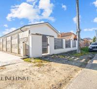 Rodinný dům v Orechovej Potôni s kamenným plotem a zaparkovaným autem na ulici.