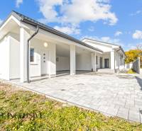 Rodinný dům v Orechové Potôni s bílou fasádou a dlážděným vstupem.