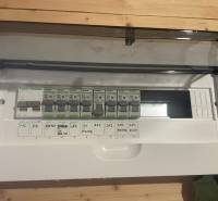 Elektrická rozvodná skříň v chatě s podlahou s dřevěným dekorem.