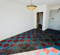 Pokoj v 1-pokojovém bytě s barevnou kachlovou podlahou a závěsným svítidlem.