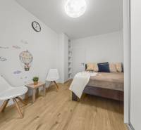 Ložnice v 2-pokojovém bytě s dekorem na stěně a podlahou s dřevěným dekorem.