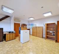 Kanceláře s podlahou s dřevěným dekorem, dřevěným nábytkem a klimatizací.