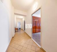 Chodba s dlažbou a vstupem do místnosti ve 4-pokojovém bytě.