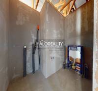 Nezařízená místnost ve stavbě rodinného domu, s viditelnými instalacemi.