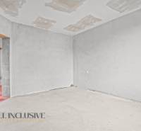 Pokoj v rodinném domě s nedokončenou podlahou a stropem.