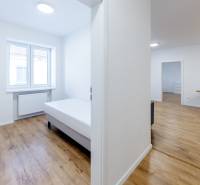 Světlý 3-pokojový byt s postelí a podlahou s dřevěným dekorem.