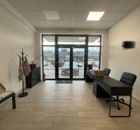 Interiér obchodních prostor s nábytkem a podlahou s dřevěným dekorem.