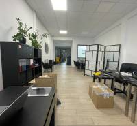 Obchodní prostory s poličkou, stoly, křesly a podlahou s dřevěným dekorem.