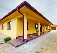 Rodinný dům na Jetelové ulici v Iži s upraveným dvorem a popínavými rostlinami.