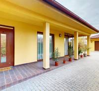 Rodinný dům na Jetelové ulici v Iži s garáží a podloubím, obklopený zelení.