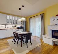 Kuchyně a jídelna v rodinném domě s podlahou s dřevěným dekorem a krbem.